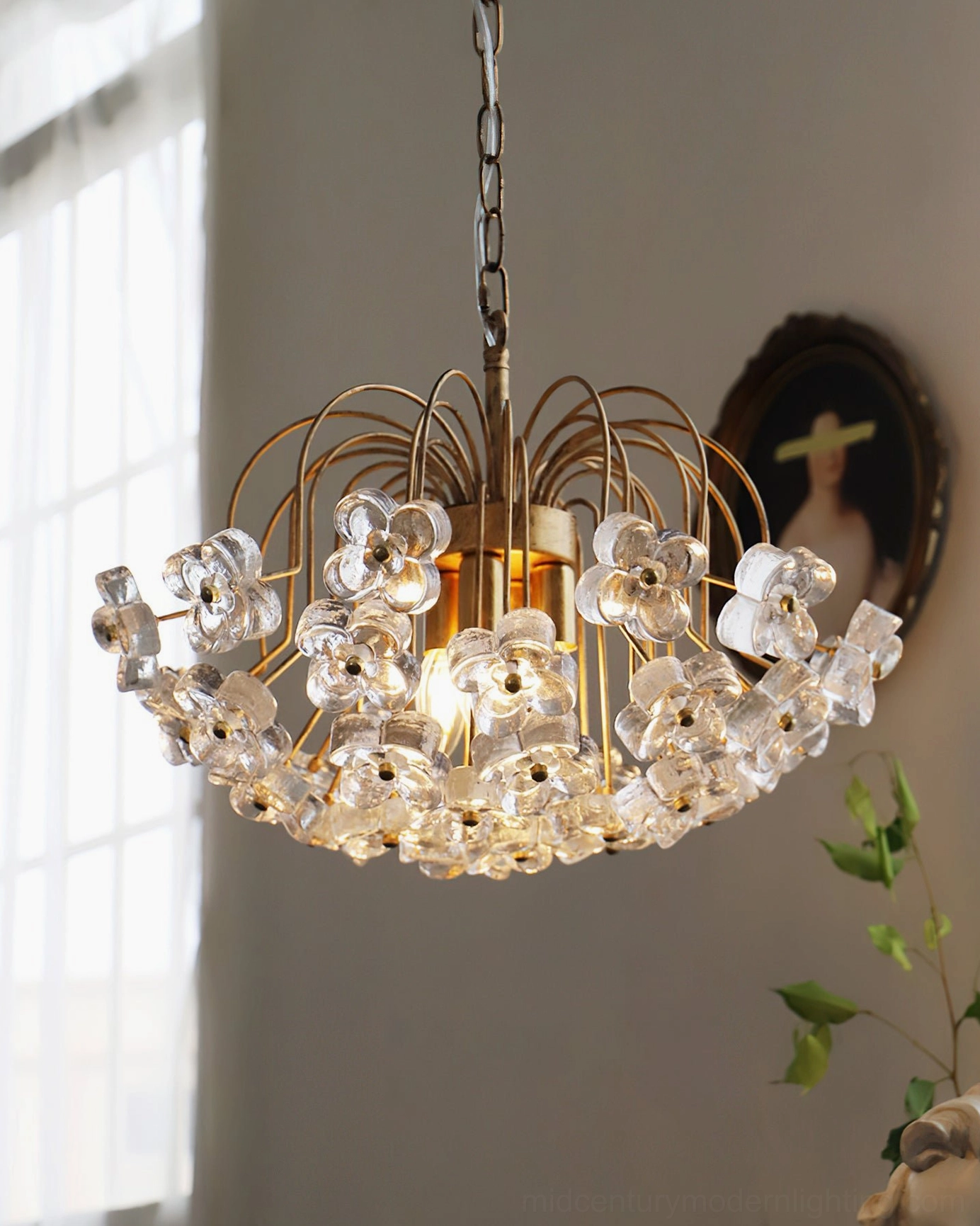 Illuminated Blossom pendant light creating elegant shadows in vintage living room with portrait and botanical decor