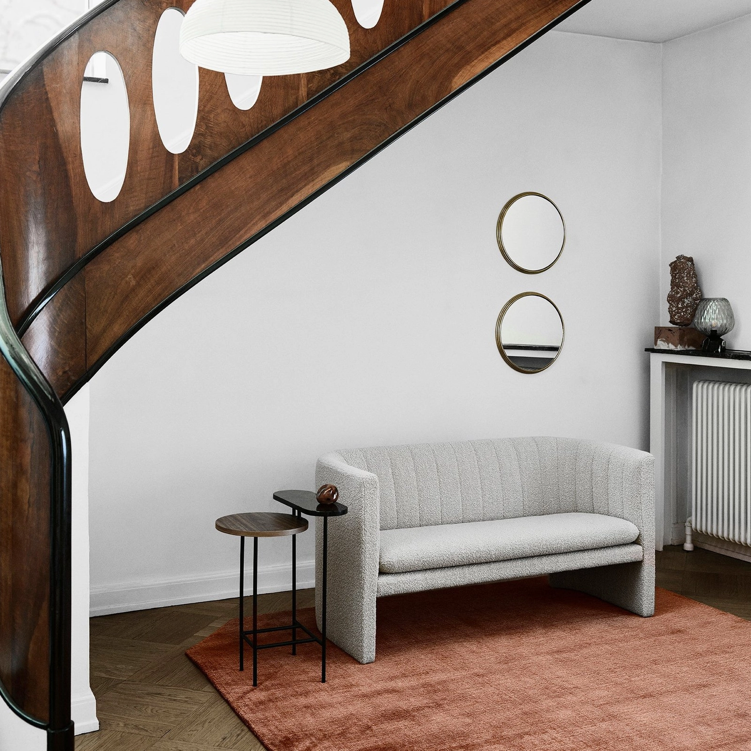 Modern home interior featuring blown glass table lamp in stairside lounge area with neutral warm décor