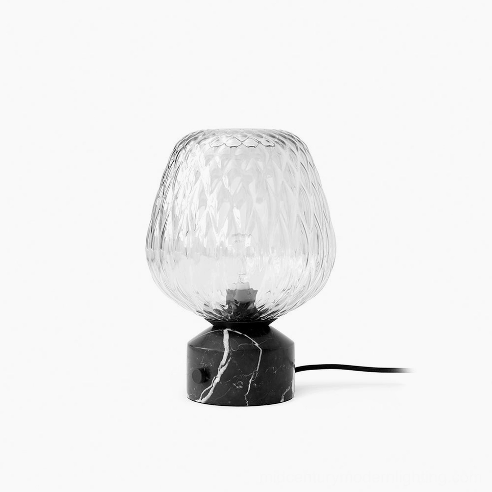 Blown glass table lamp with quilted texture and black marble base, front studio view showcasing modern sculptural design