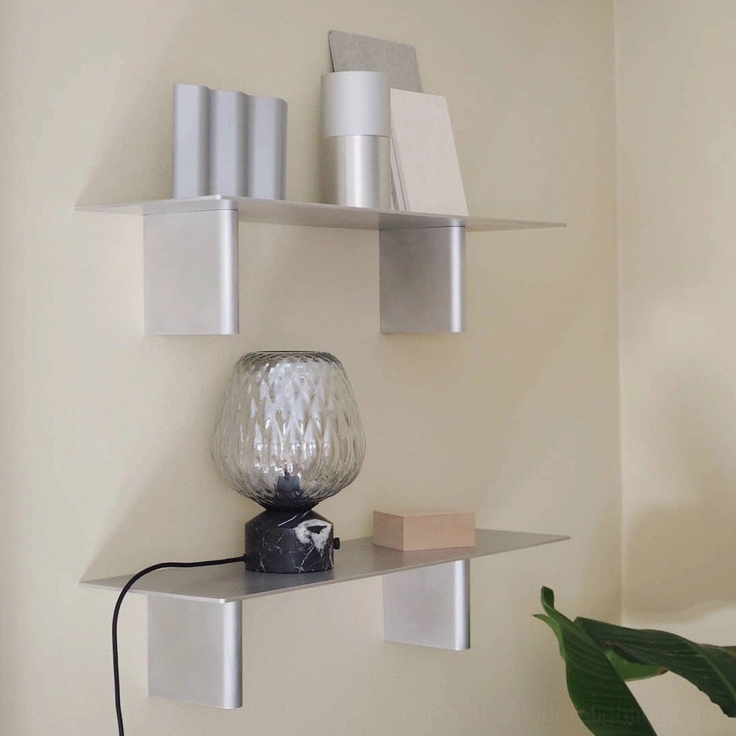 Textured glass lamp on modern metal shelf display, paired with minimalist home décor accessories
