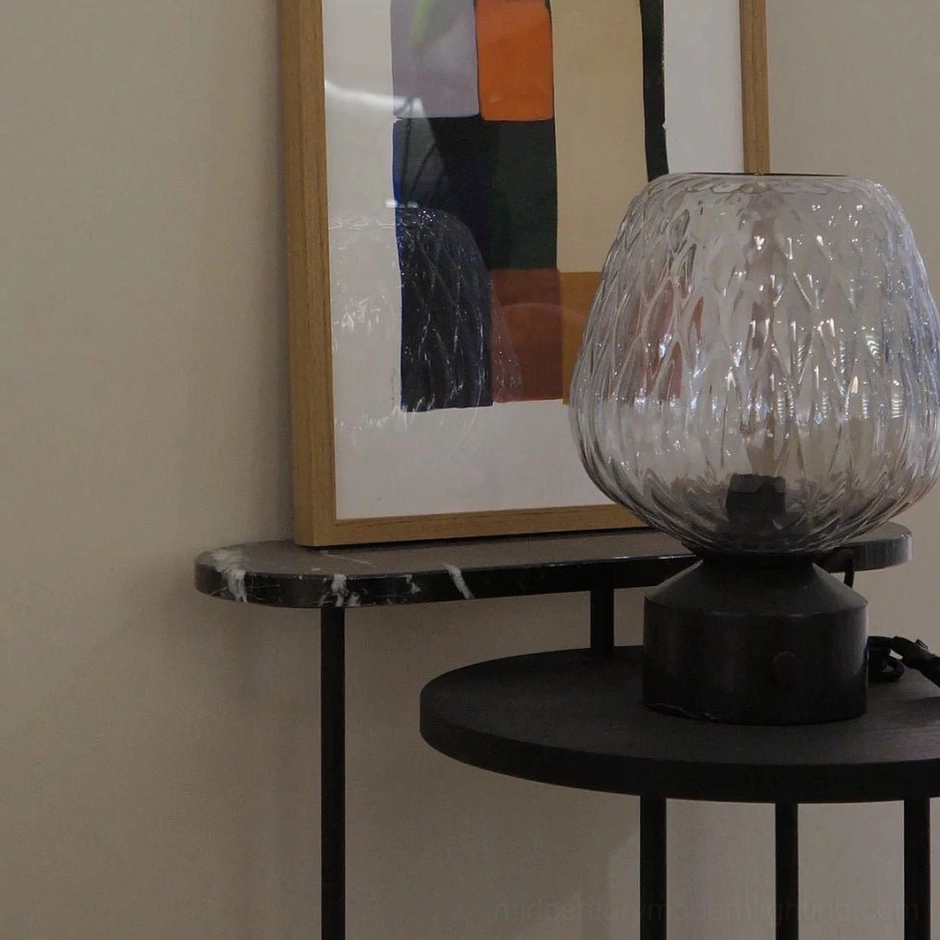 Contemporary table lamp on black metal and marble side table in living room with abstract wall art