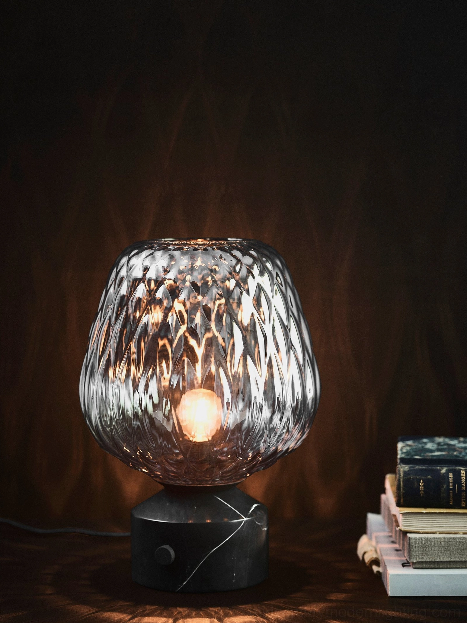 Blown glass table lamp close-up showing organic quilted surface texture and light refraction properties