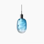 Gradient blue sculptural glass pendant light with frosted cloud-shaped shade and brass metal top, studio front view
