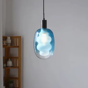 Blue gradient pendant light installed in minimalist wooden shelf interior, brass accents, warm ambient glow