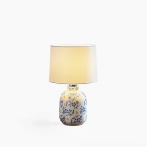 Avalyn blue and white ceramic table lamp with floral motif base and white fabric drum shade, front view on white background