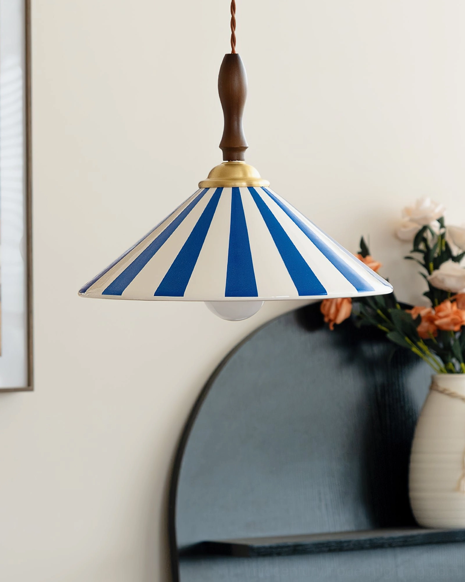 Blue and white striped Bobine ceramic pendant light hanging on home shelf with floral vase, coastal retro design