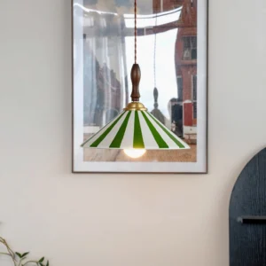 Green and white striped Bobine pendant light hanging from braided cord, exposed vintage bulb, living room interior styling