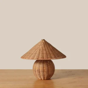 Bobine rattan table lamp on wooden table, close-up detail showing woven rattan texture and gold metal accents
