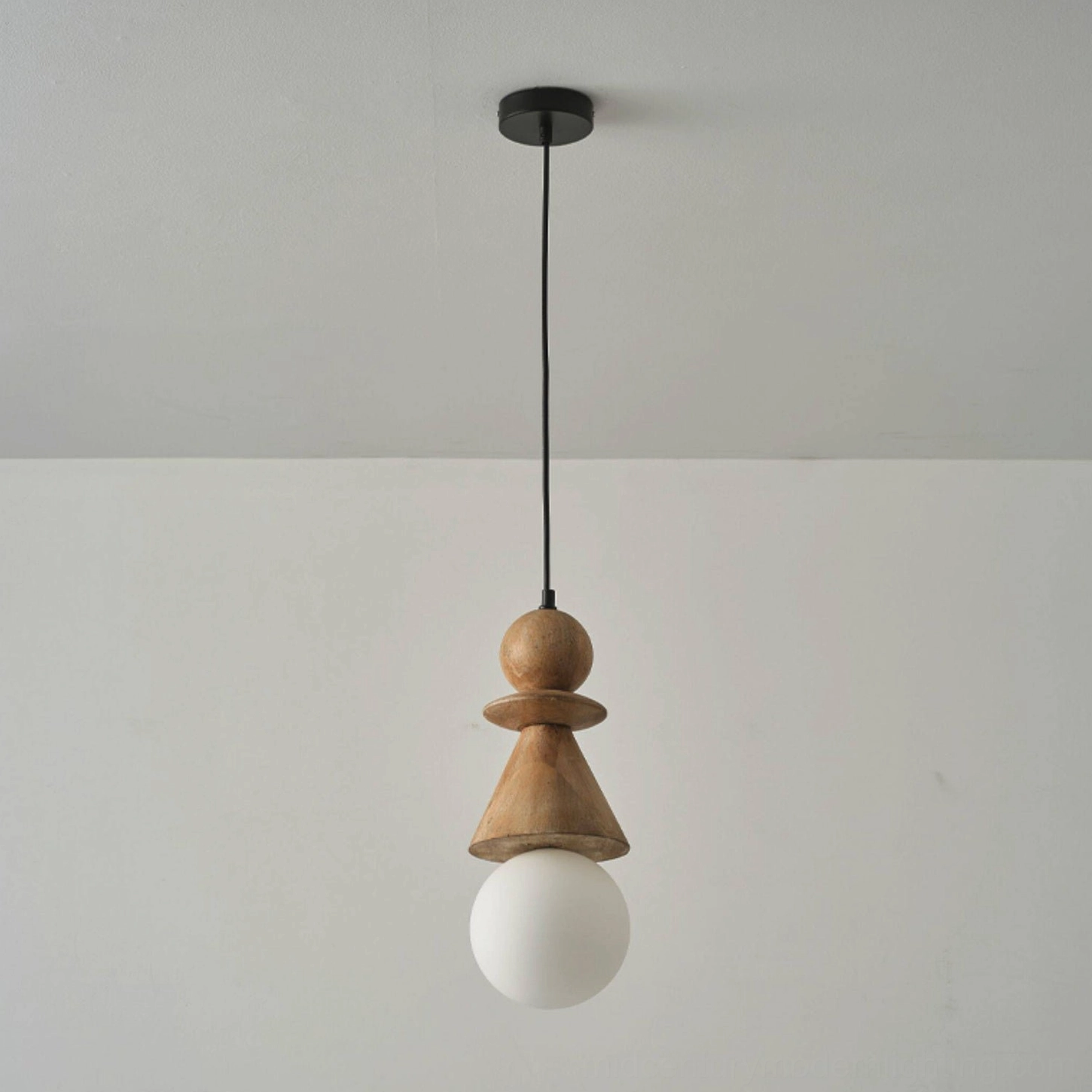 Bodie matte black totem pendant light installed in modern ceiling corner with frosted bulb, overhead view from below
