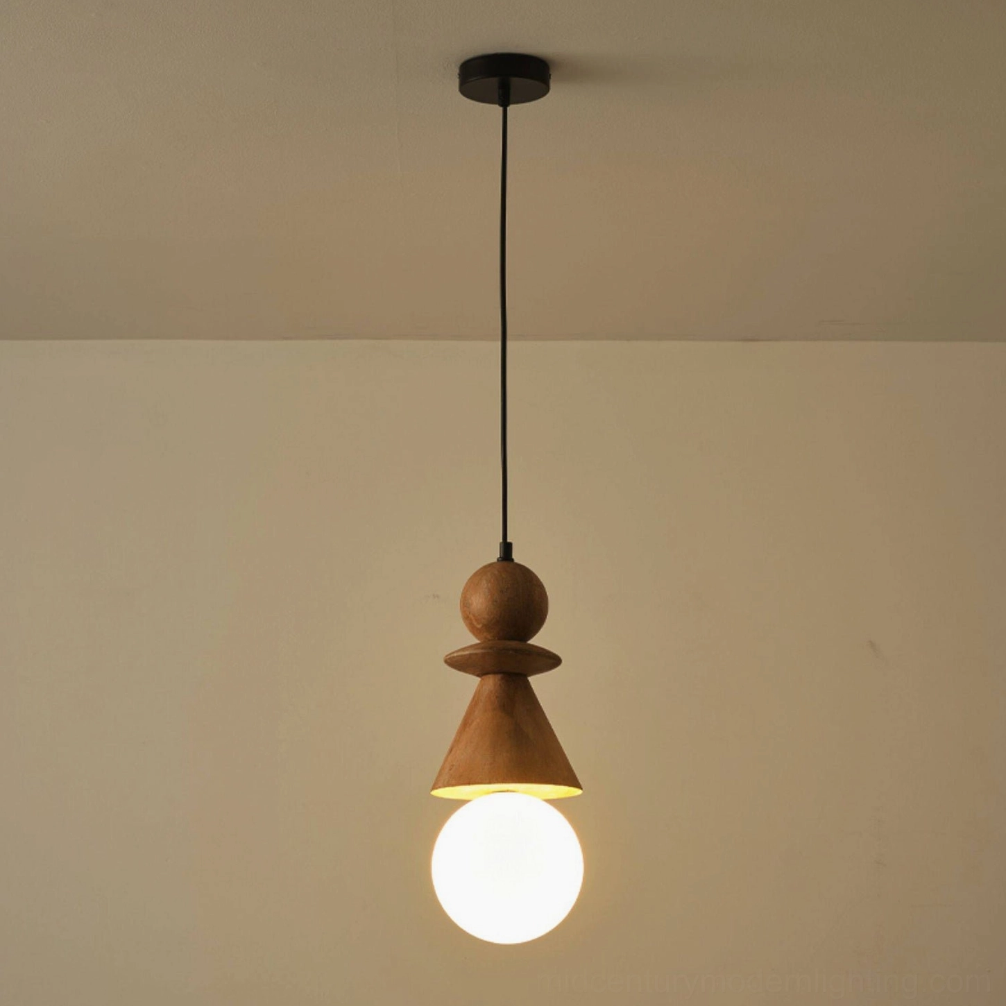 Natural wood totem pendant light with illuminated frosted white bulb against warm beige interior background, close-up perspective