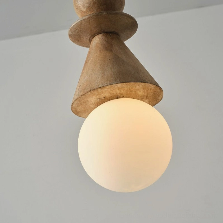 Wooden totem pendant light with conical shade and glowing frosted globe bulb in close-up against light gray wall, artistic perspective
