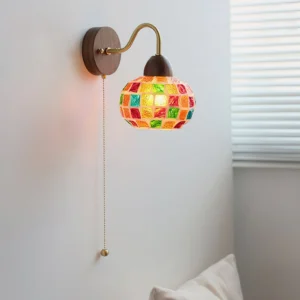 Mid-century modern mosaic wall lamp with pull-chain switch and brass curved arm mounted in bedroom corner - side oblique view