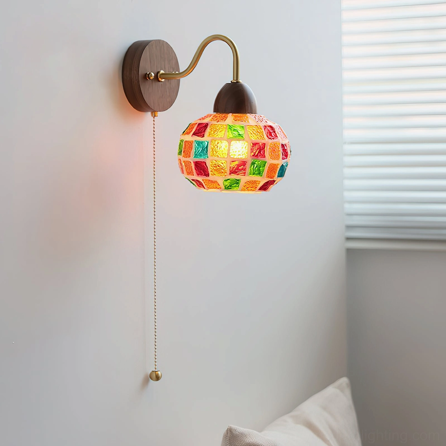 Mid-century modern mosaic wall lamp with pull-chain switch and brass curved arm mounted in bedroom corner - side oblique view
