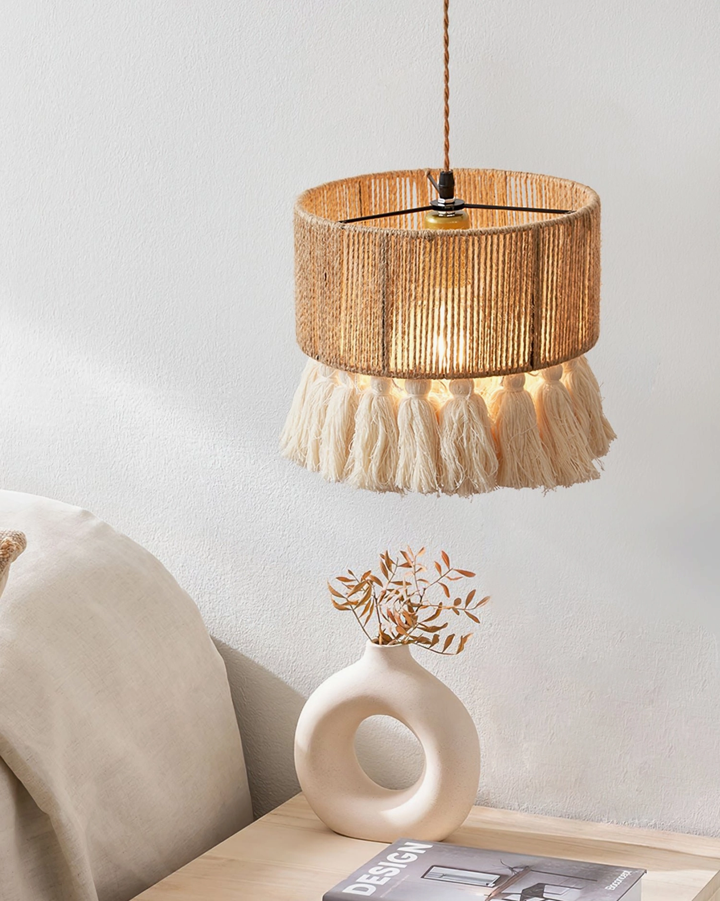 Boho tassel pendant lamp in living room setting with ceramic vase and dried botanical decor, side angle view