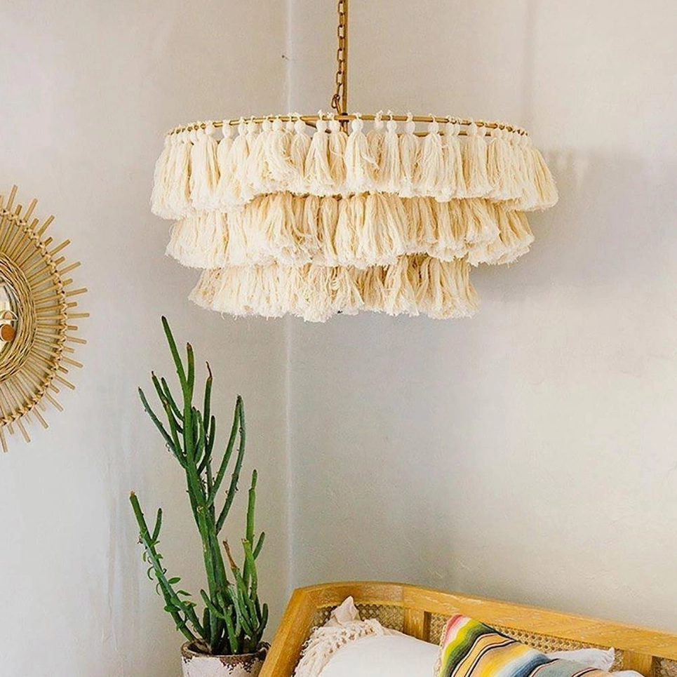 Cream tassel pendant with warm fabric tones complementing natural wood beams and global décor
