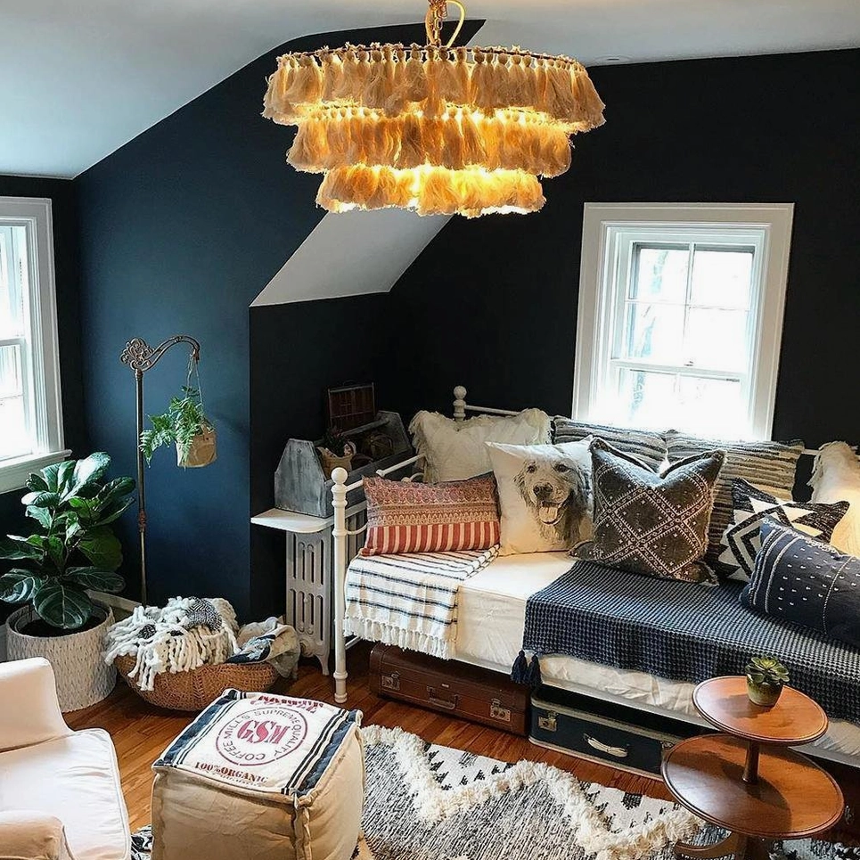 Warm beige tiered tassel chandelier illuminated in bohemian living room with daybed and natural daylight