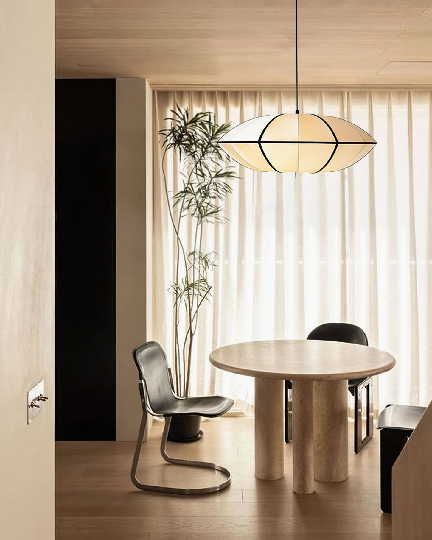 Bombori pendant light above round dining table with sheer curtains and plant