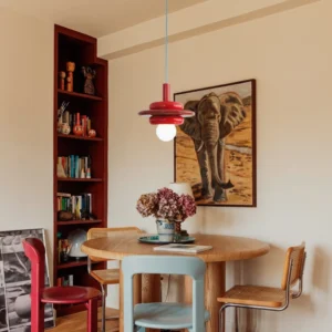 Bomiello red pendant light hanging above wooden dining table in vintage eclectic dining room
