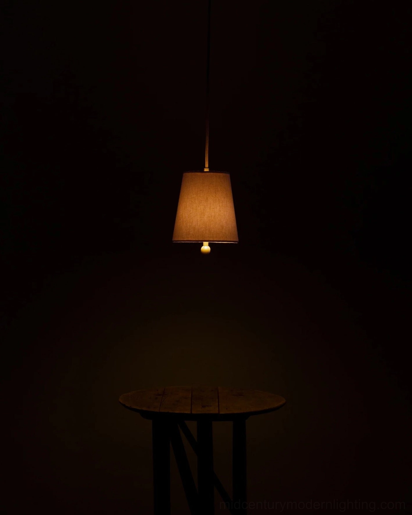 Bonny pendant lamp hanging in dark home setting with subtle warm ambient lighting effect
