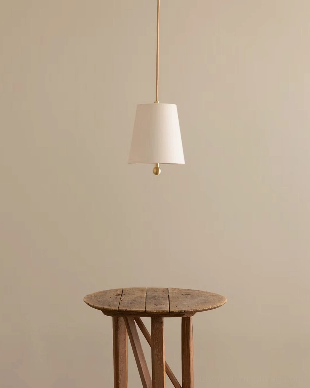 Bonny pendant lamp installed in warm home interior above wooden side table, creating ambient lighting