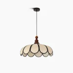 Botan scalloped pendant light with beige abaca fiber shade and black petal trim, walnut wood ceiling cap, studio front view