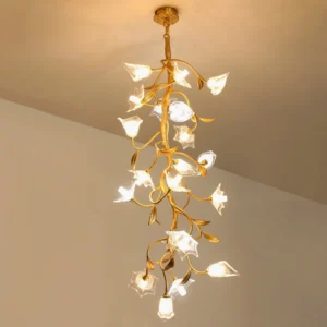 Modern botanical chandelier lit with warm LED light, winding gold branches with delicate glass flowers in living room setting