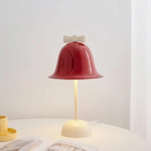 Bow Bell table lamp styled on white round side table with yellow cup and saucer, home design magazines, interior décor setup
