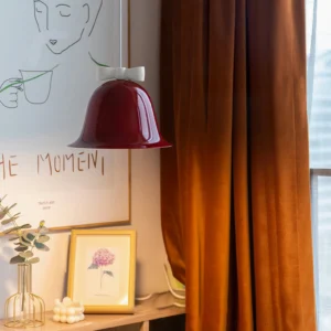 Bow bell pendant lamp in vintage bedroom setting, warm ambient lighting with wine-red shade and white bow