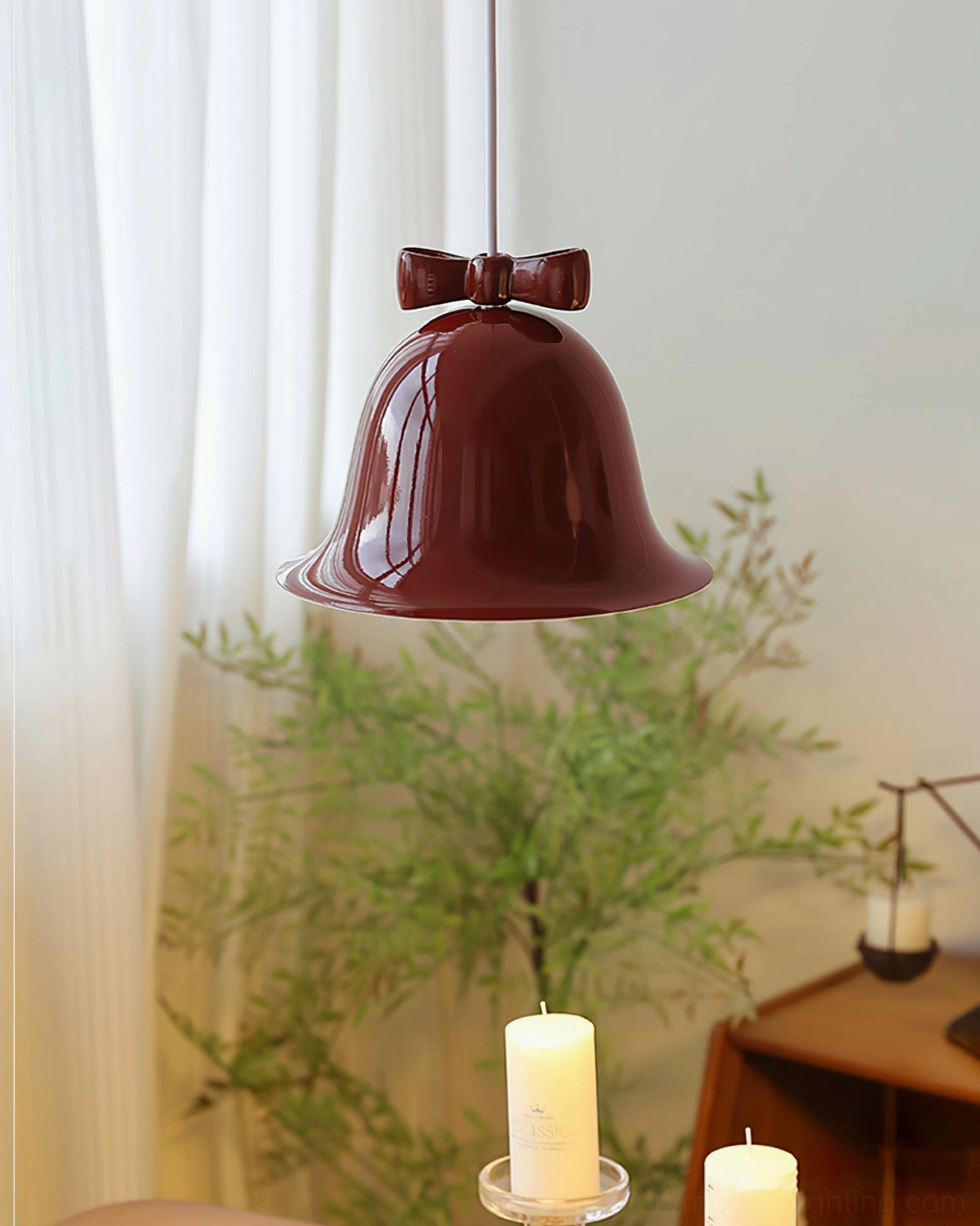 Two bow bell pendant lamps side by side, wine-red and cream beige, in warm dining room setting