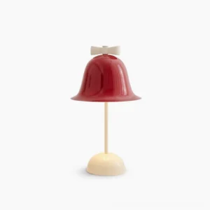 Bow Bell mid-century modern table lamp with burgundy red shade and cream white stand featuring decorative bow detail, front studio view