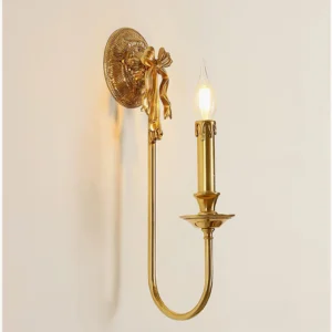 Front view of curved bow brass wall light with decorative bow ornament detail