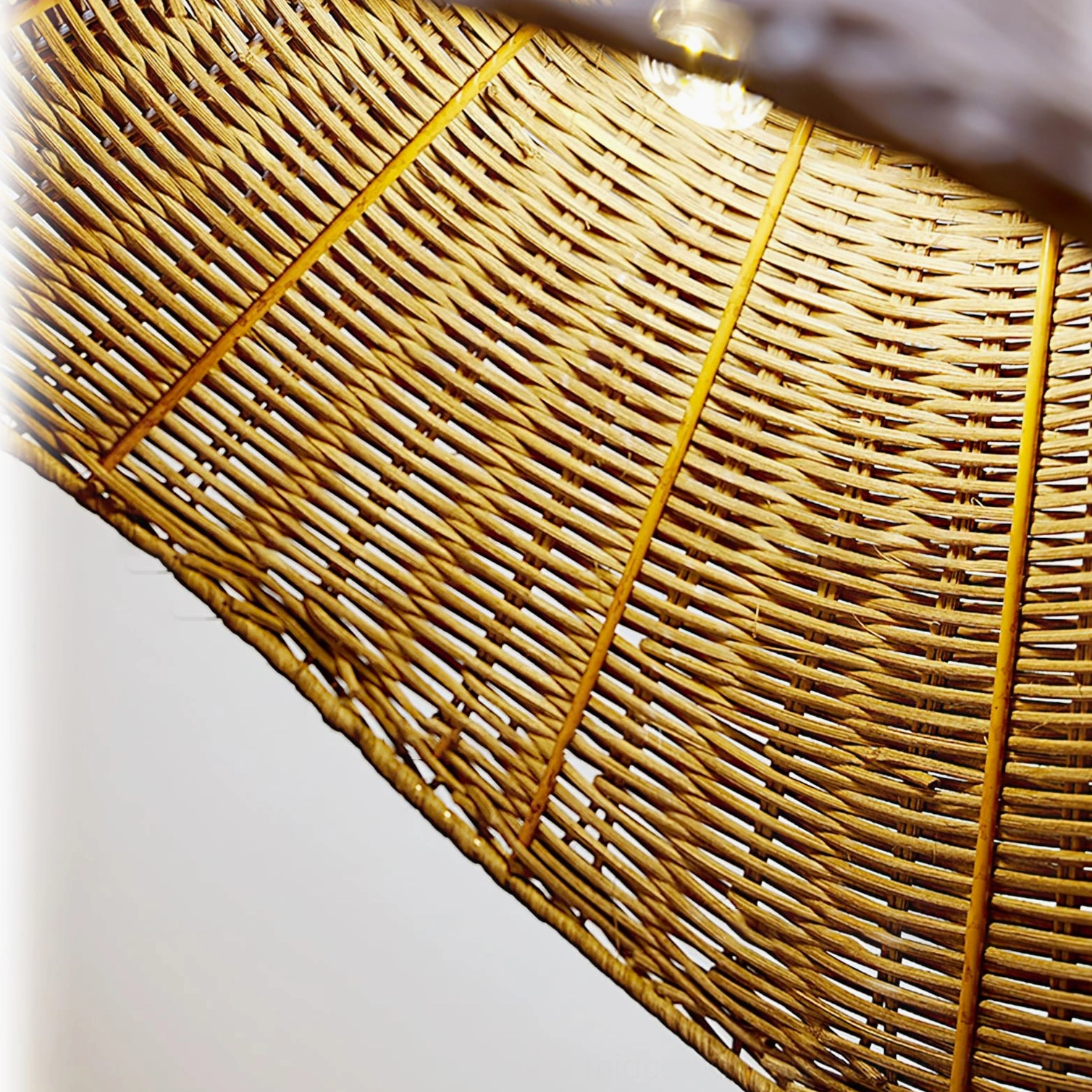 Close-up overhead view of hand-woven rattan lampshade texture with yellow stripes, showcasing traditional weaving craftsmanship