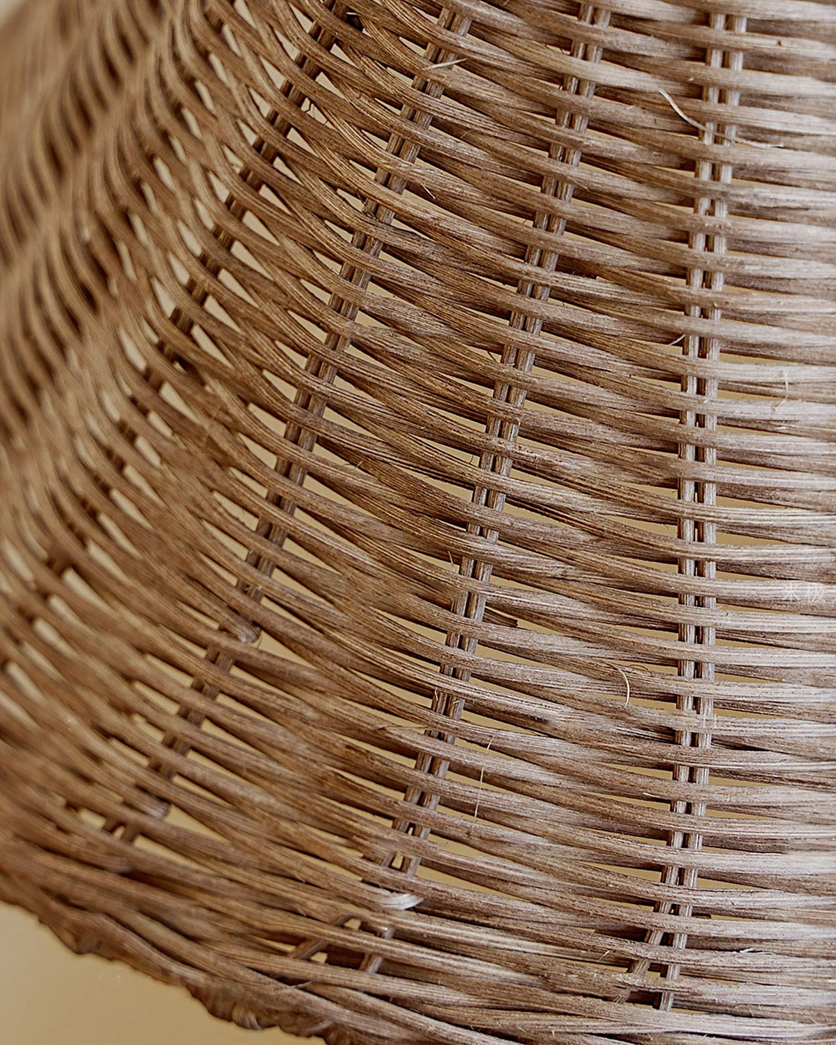 Detailed overhead shot of dense grey-brown hand-woven wicker rattan texture, Brady lampshade weaving pattern