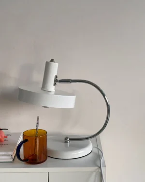 Modern Brano desk lamp on home side table with coffee mug and stacked books, interior styling