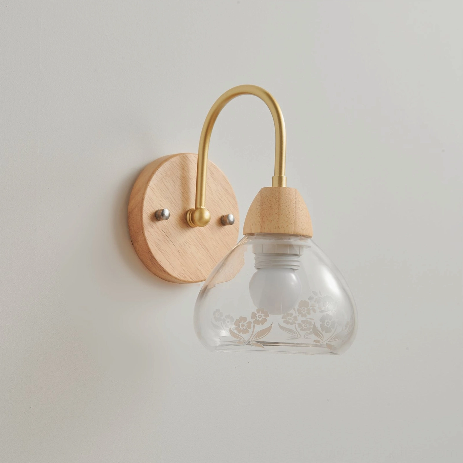 Armed wall lamp brass and wood construction highlighted in studio photography