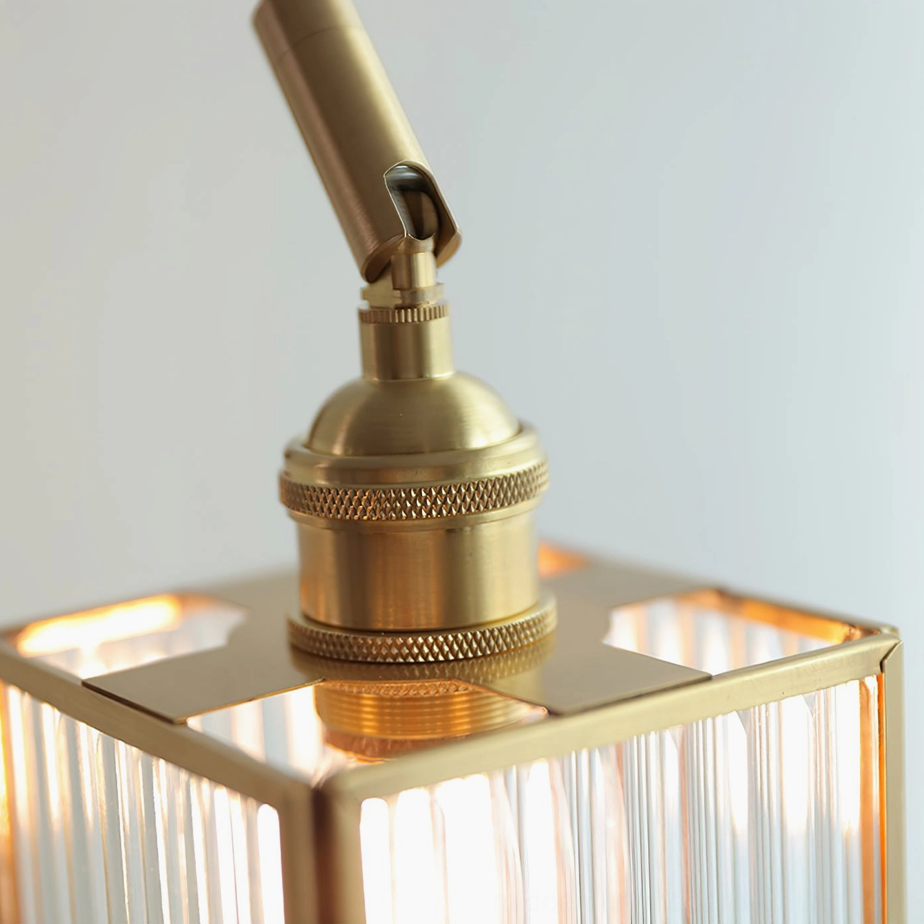 Macro detail of brass swing arm joint with knurled hardware mechanism showing mid-century modern construction