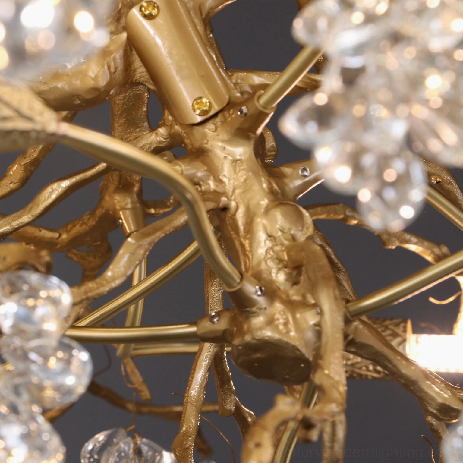 Macro close-up detail of polished gold brass tree branches with faceted crystal grape clusters and decorative pendant elements