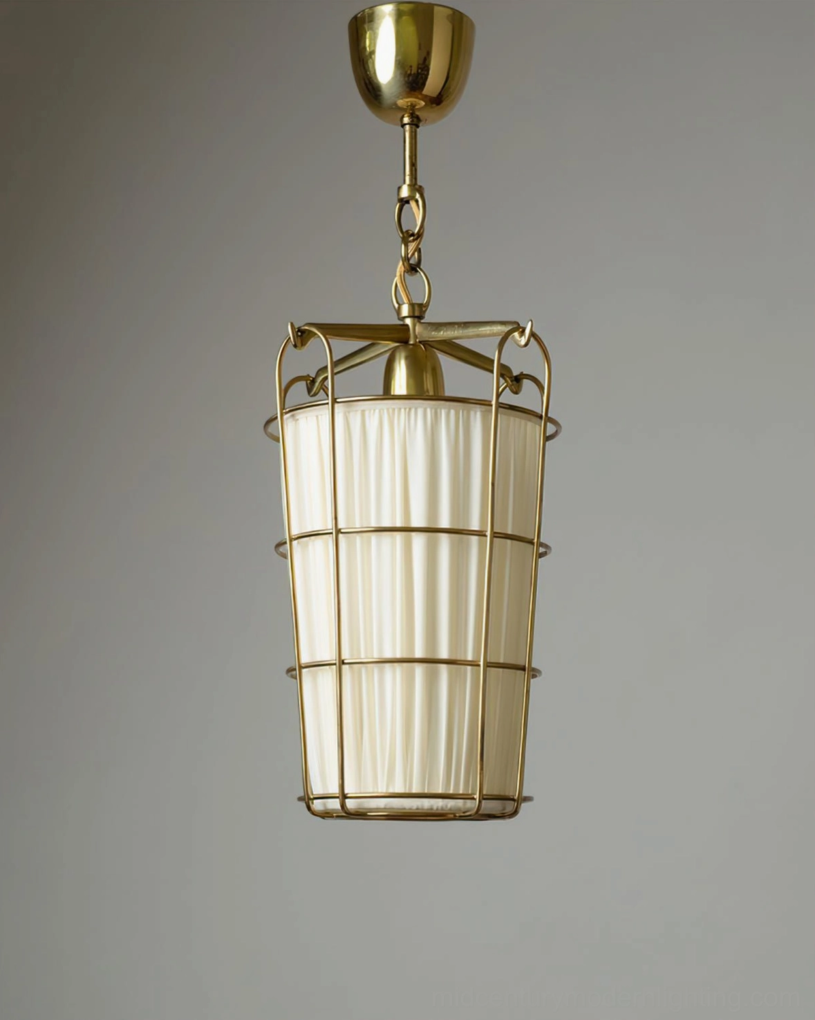 Unlit caged pendant chandelier with pleated off-white shade and brass metal frame, studio product photo