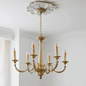 Brass candle chandelier mounted on ornate ceiling medallion in classic bedroom with carved ceiling trim