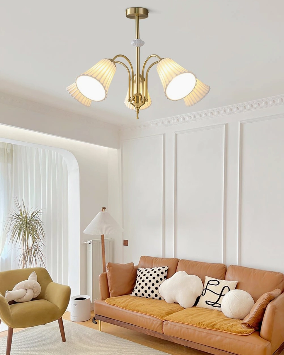 Overhead view of 4-head brass pendant chandelier in modern French living room interior with leather sofa and contemporary furnishings