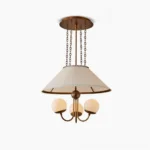 Antique bronze brass chandelier with pleated shade and three globe glass bulbs, front studio view