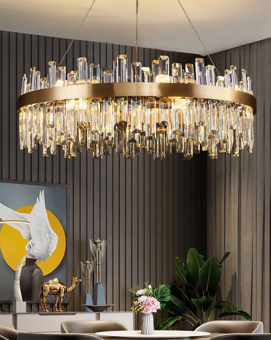 Brass crystal statement chandelier in dark wood dining room with warm tabletop decor and glowing light