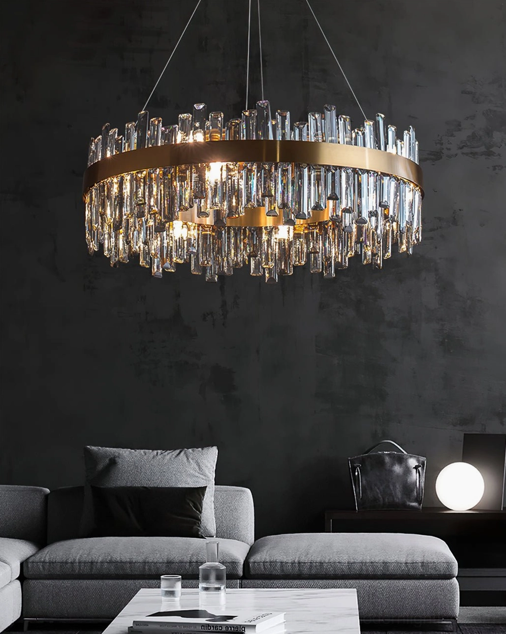 Brass crystal chandelier in contemporary grey fabric lounge with gold frame and clear crystal droplets warm lighting