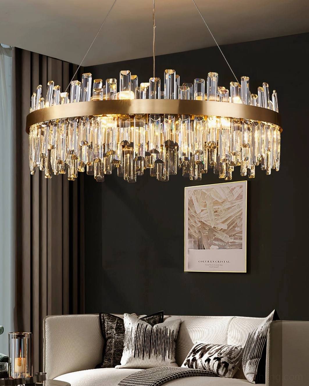 Illuminated brass crystal chandelier in light grey sofa living room with wall artwork, glowing warm light design