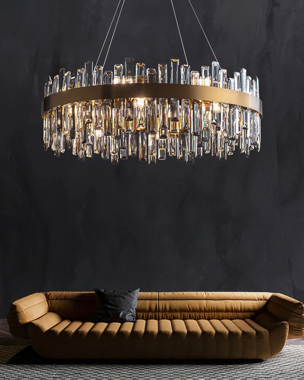 Luxury brass crystal chandelier in high-end living room with tufted tan sofa, dark accent wall, gradient crystals