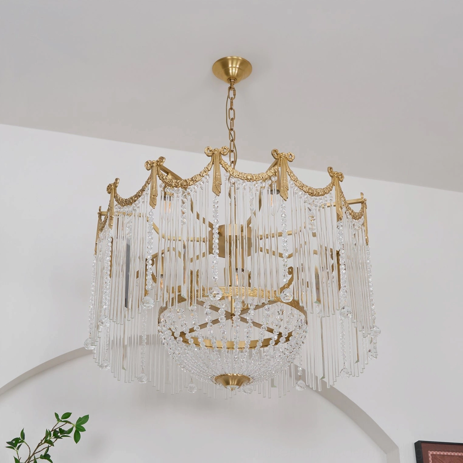 Side indoor view of gold-finished crystal chandelier with multi-layer glass tassels and crown top frame