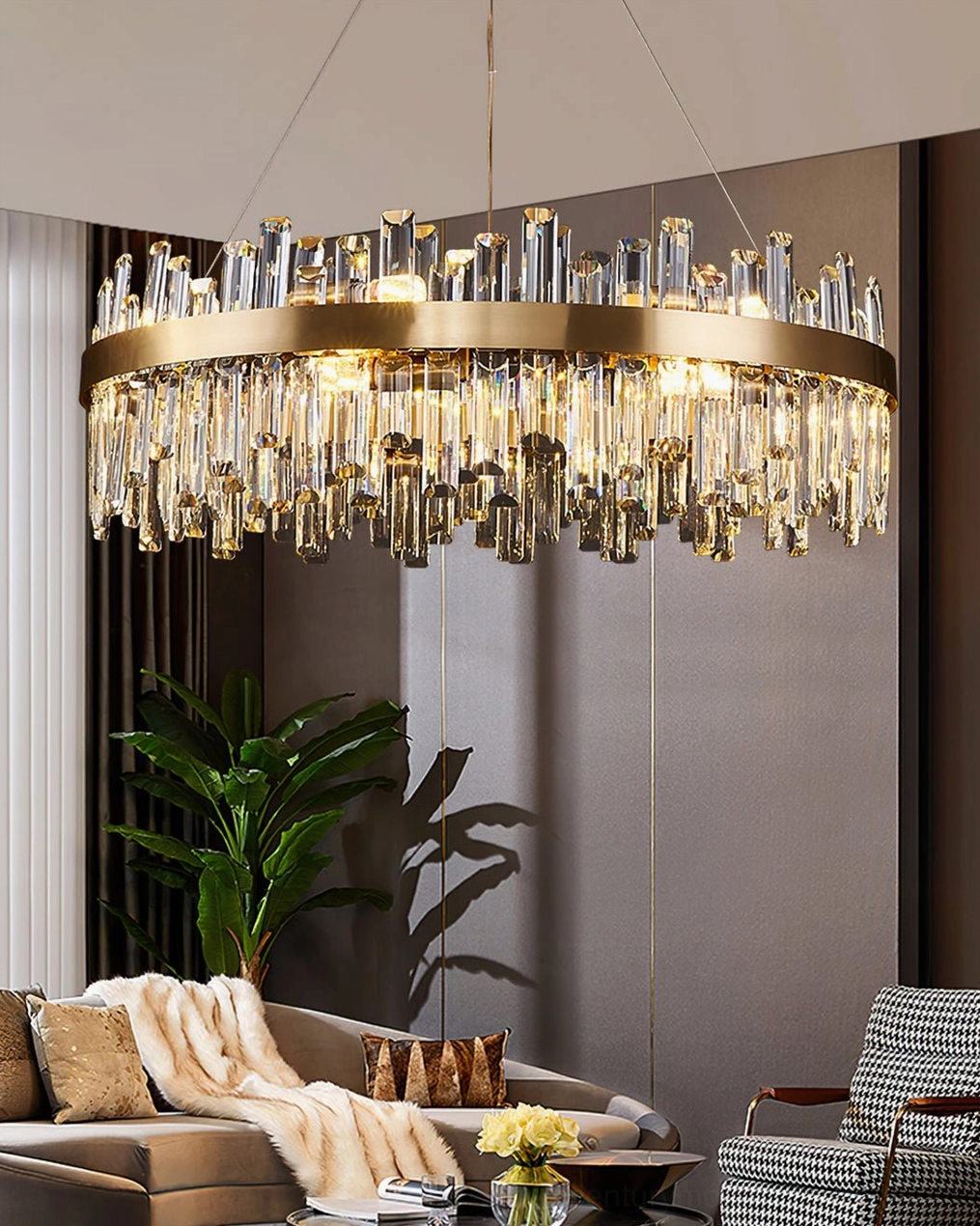 Round brass crystal chandelier above tan sofa with checkered accent chair, lit with vertical crystal droplets