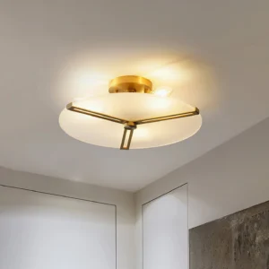 Flush mount brass ceiling lamp installed in minimalist residential corner with warm lighting