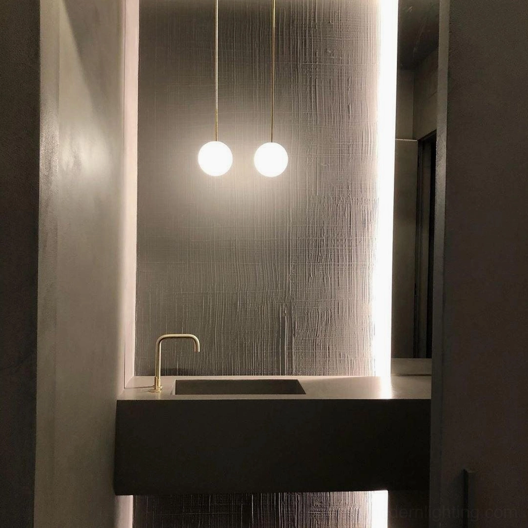 Brass globe pendant lights flanking modern bathroom vanity with minimalist design