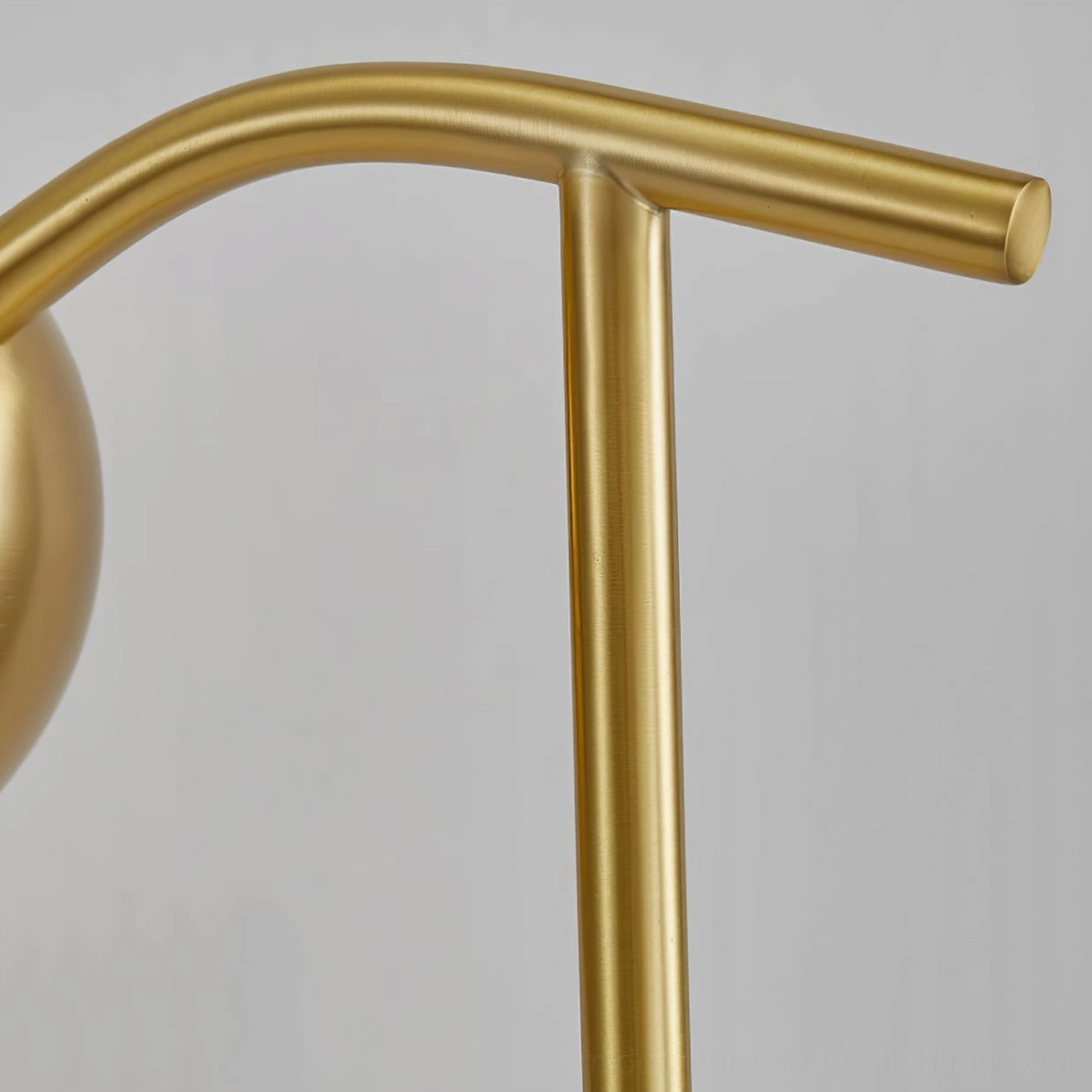Close-up detail of brushed brass gooseneck metal arm showing smooth curved metalwork and gold finish texture